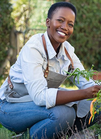Smiling gardener tending to plants outdoors.