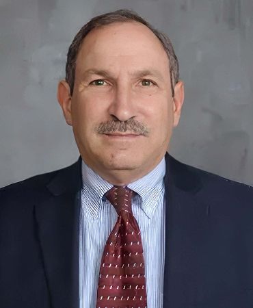 Man in glasses wearing a suit and tie.