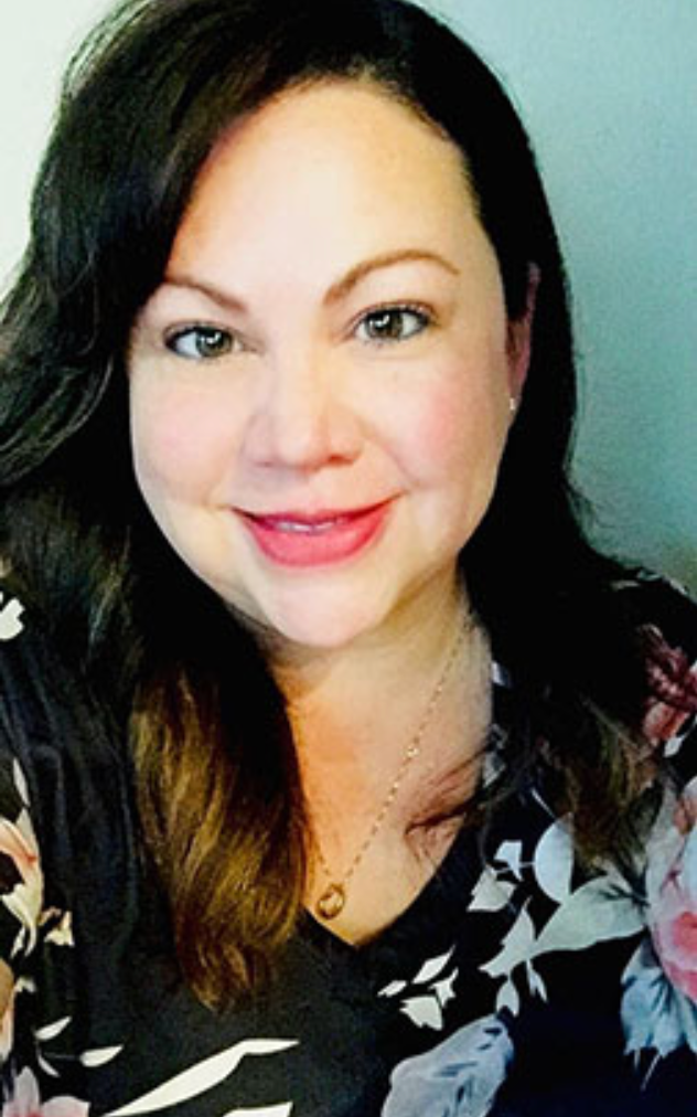 Woman smiling with floral shirt and necklace.