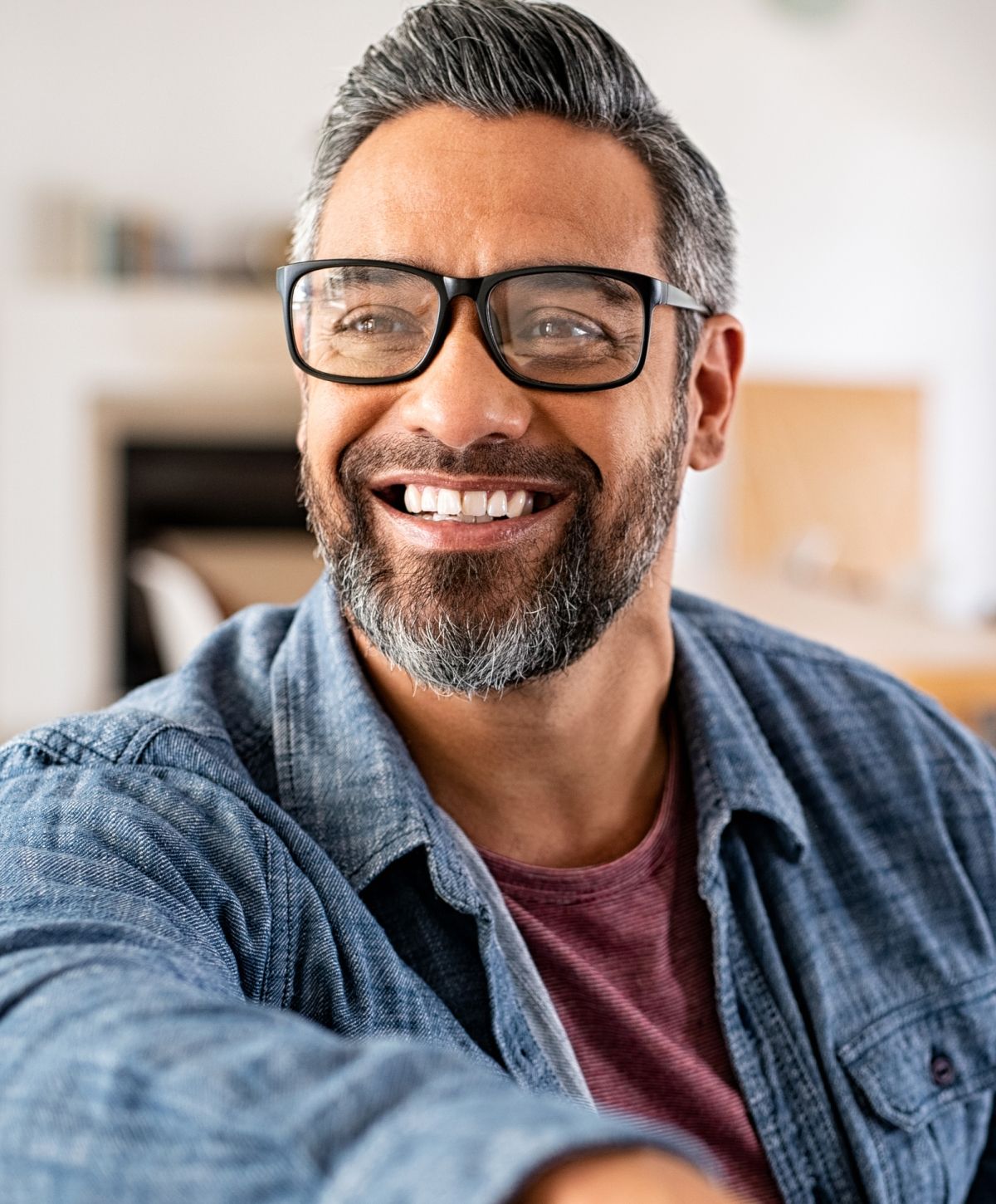 Smiling man wearing glasses and casual clothing.