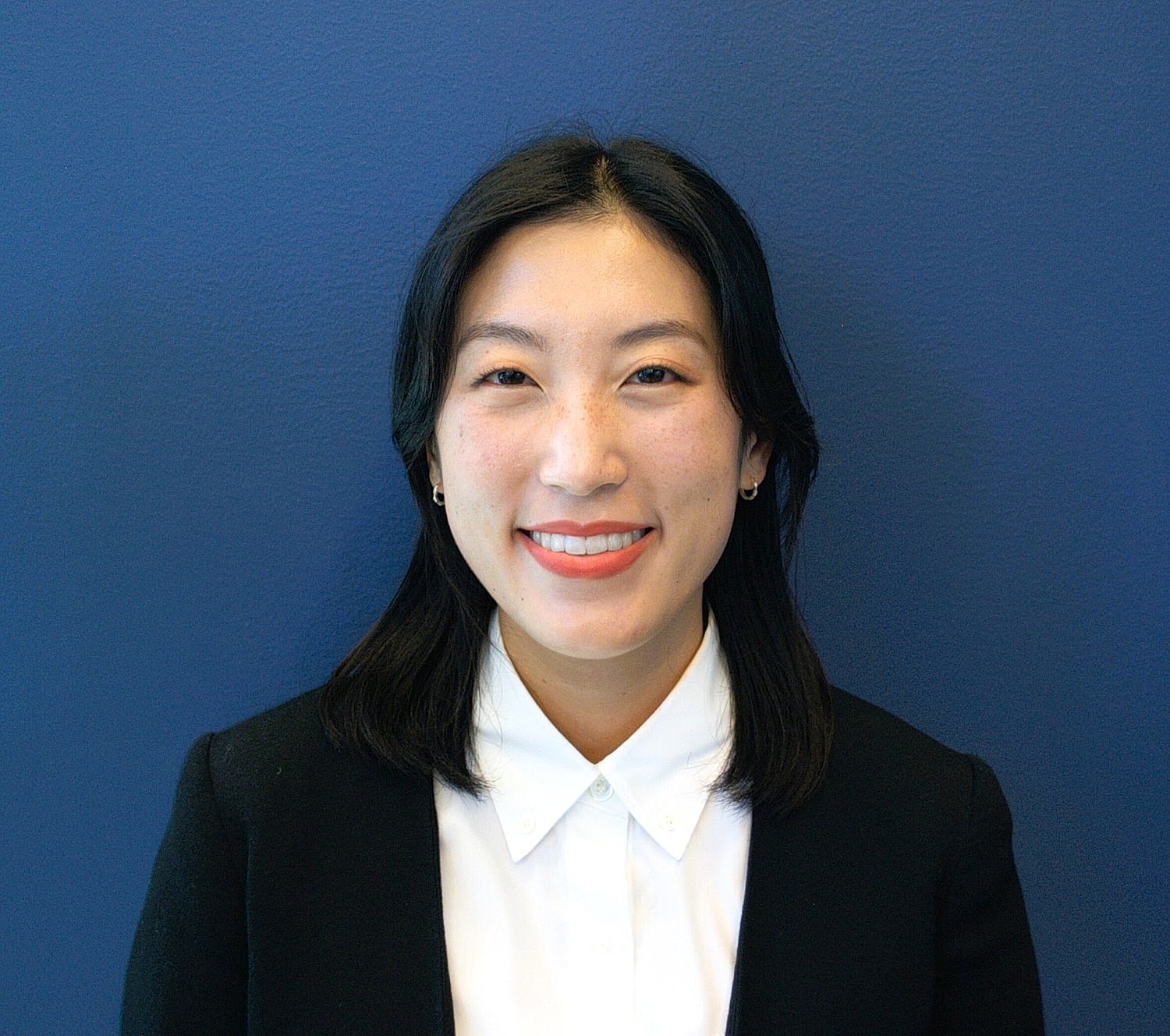 Smiling person against a blue background.