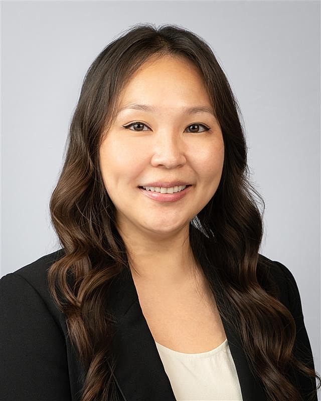 Professional woman smiling in formal attire.
