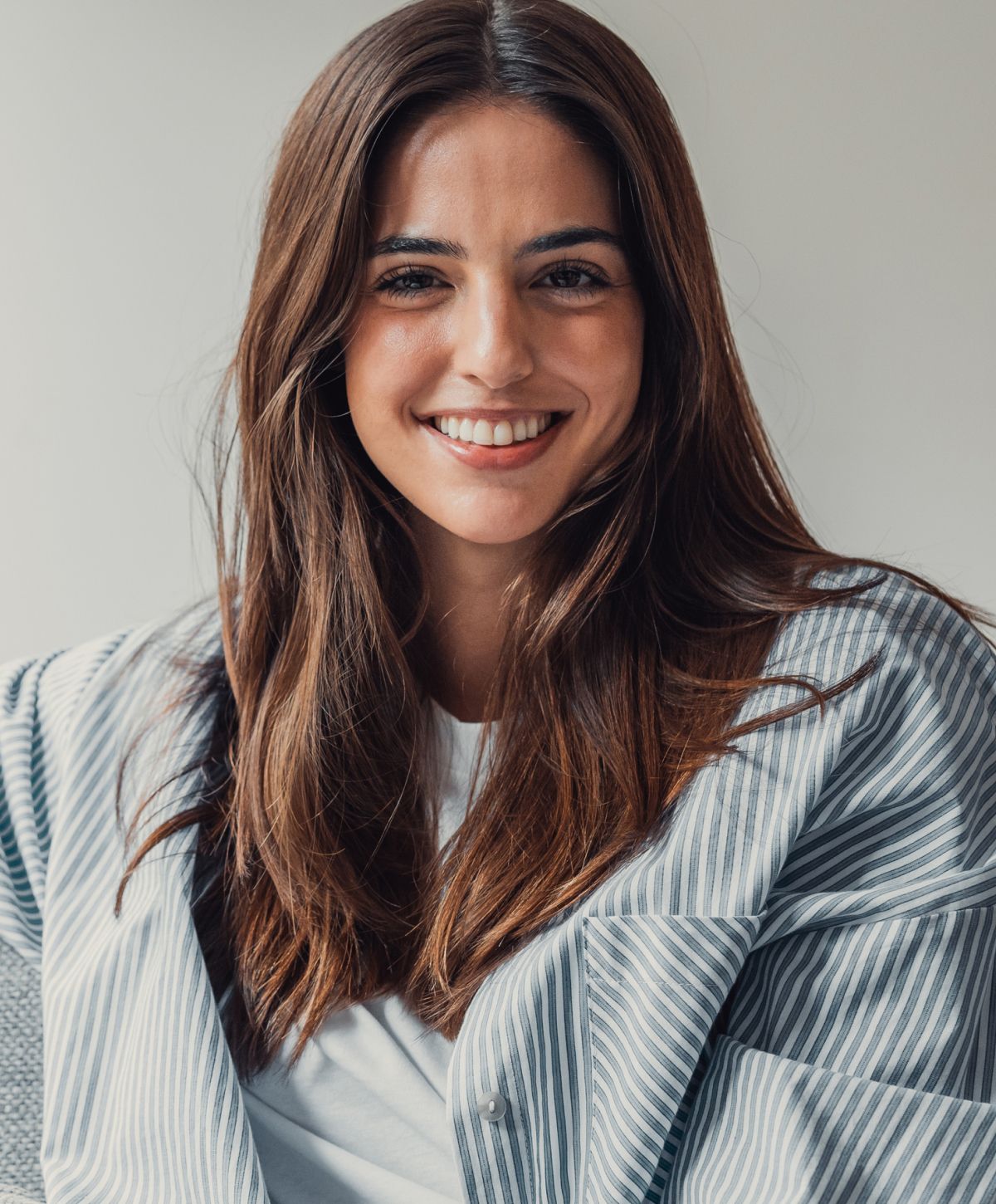 Smiling woman with long hair in casual attire.
