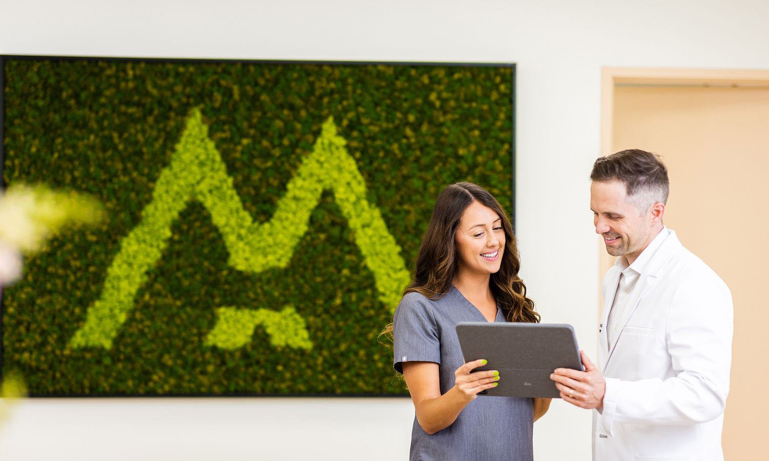 Healthcare professionals discussing on a tablet.