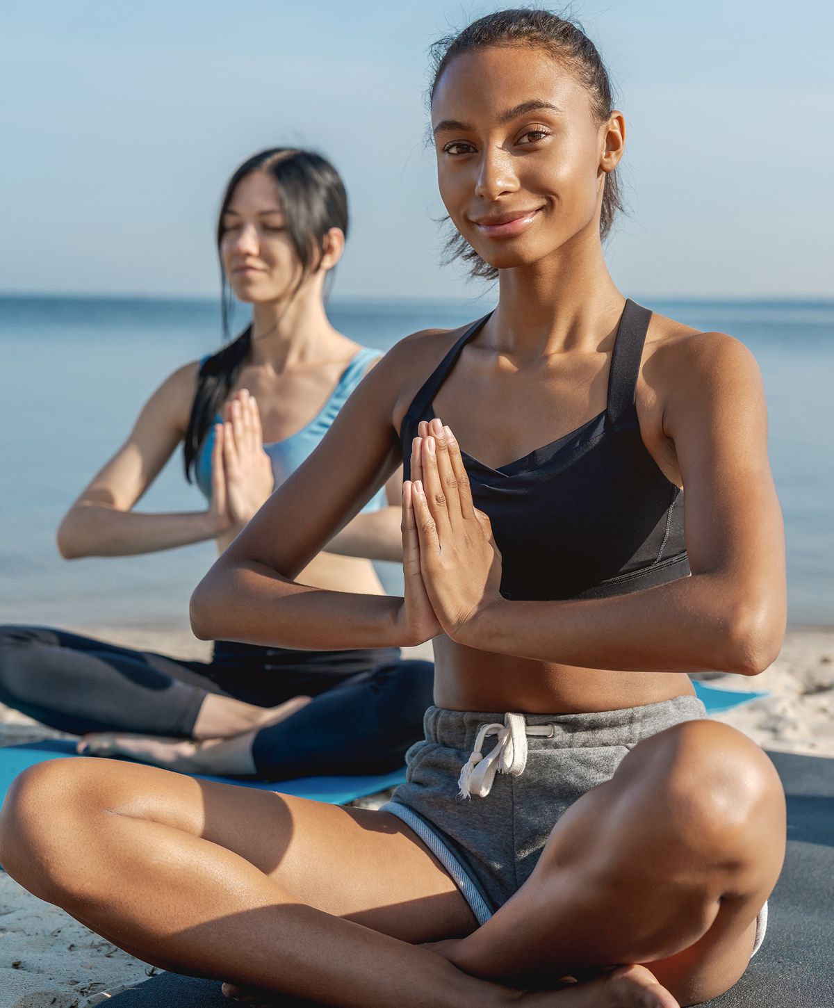 Women practicing yoga on the beach.