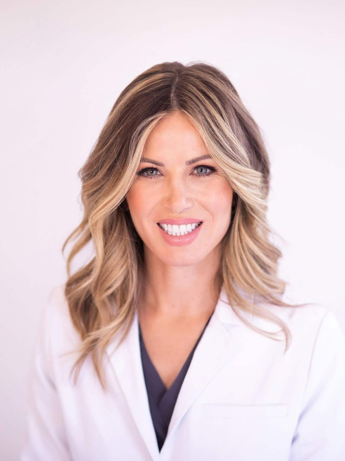 Female doctor smiling in professional attire.