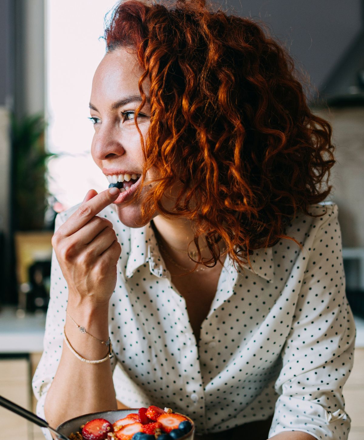 Woman enjoying a colorful breakfast bowl.