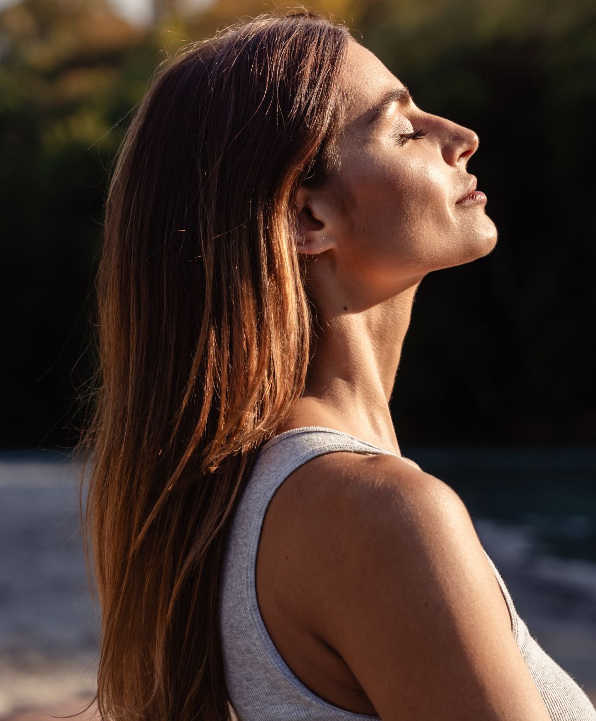 Woman enjoying sunlight by the water.
