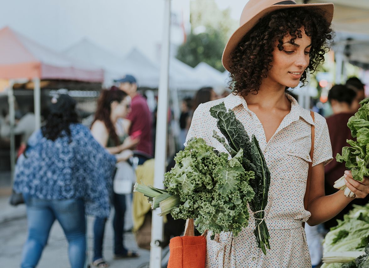 Woman shopping for fresh vegetables at market.