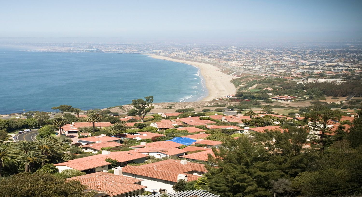 Coastal view overlooking houses and sandy beach.