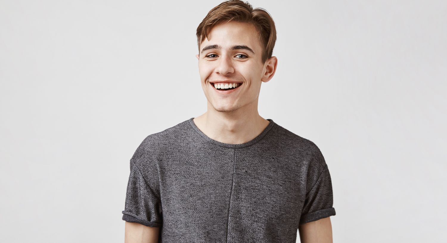 Smiling young man in a gray shirt.